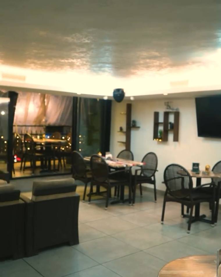 The lounge: round wooden tables and rattan armchairs